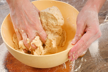 Unleavened dough for tortillas with flour and hand on kitchen table. Cooking burrito.
