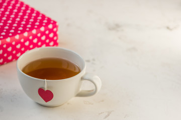Cup of tea with heart teabag and gift boxes