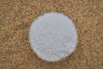 Close-up of grains of uncooked white  jasmine rice in  bamboo container . Jasmine rice is grown primarily in Thailand (Thai hom mali or Thai fragrant rice)