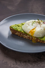Sandwich with avocado and poached egg. Healthy breakfast