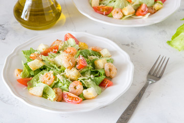Caesar salad with shrimps on a white background