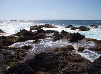 Fototapeta na wymiar Wild coast with lava stones. On the west coast of the island Sao Miguel, archipelago of the Azores, belonging to Portugal, Europe.