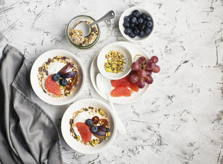 Seasonal healthy breakfast: yoghurt, chocolate granola, pink grapefruit, grapes, pistachios. Top view. Copy space. flat lay
