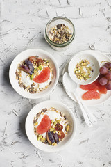 Seasonal healthy breakfast: yoghurt, chocolate granola, pink grapefruit, grapes, pistachios. Top view. Copy space. flat lay