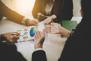 A group of business men and women are meeting together to see graphs about business marketing sales target. teamwork business meeting concept.