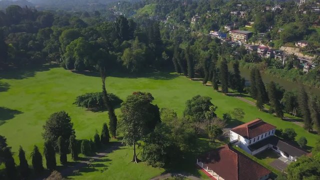 Aerial view of beautiful building at green lawn at sunset drone footage