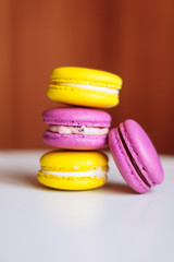 Vibrant colorful macarons on white wooden table. Text space