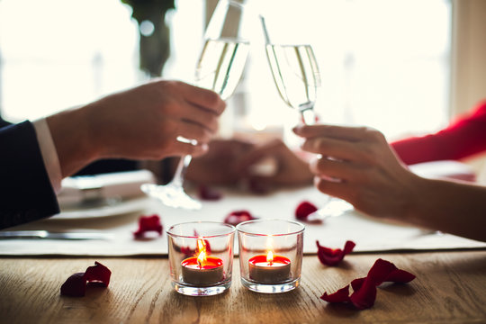 Young Couple Having Romantic Dinner In The Restaurant Drinking Champagne Cheers Close-up