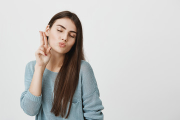 Dreamy brunette student girl with long straigh hair and appealing appearance in blue casual sweater...