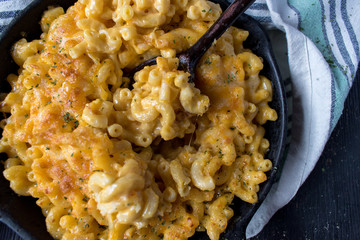 gourmet baked macaroni and cheese noodles in rustic cast iron dish top view