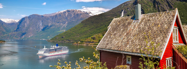 Red cottage against cruise ship in fjord, Flam, Norway © Tomas Marek
