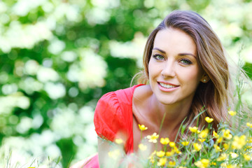 young woman in red dress lying on grass