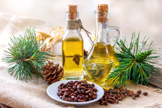 Cedar oil and pine nuts on a wooden table