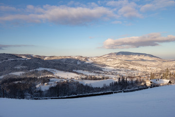 A view of the wooded hills with single houses  in the morning winter sun