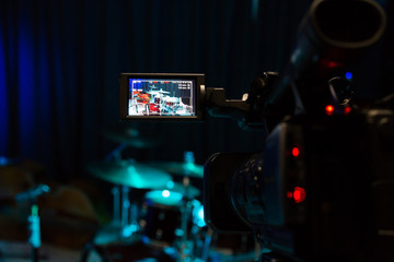 The LCD display on the camcorder. Filming the concert. Drum set and bass.