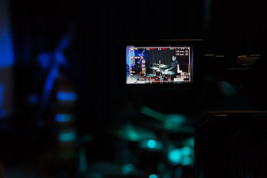LCD display on the camcorder. Filming of the concert. Musicians playing the double bass and drums.