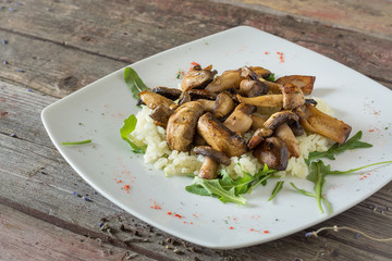 Fried mushrooms with vegetables on a plate. on a wooden background. rustic food