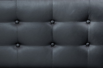 Luxury black leather sofa with buttons background.