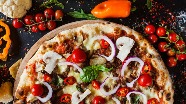 Bolognese pizza with minced meat and cherry tomatoes. Nutritional italian restaurant dish