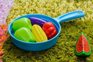 Children's toys - a frying pan and vegetables from plastic.