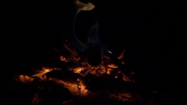 Blue and yellow fire on hot coals at night, slow motion 240 fps, hd 1080p footage