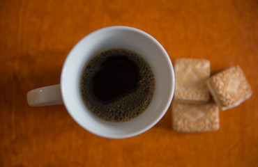 A cup of coffee with cookies  on the table