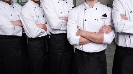 Casting process to find the best for a cooking competition. Male cooks stand confident with their...
