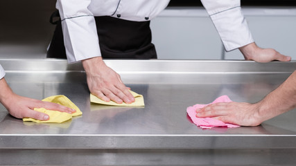 Clean kitchen - healthy customers. Restaurant team of workers clean surfaces after the shift....