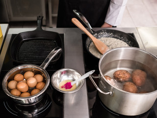 Boiled eggs and potatoes - ingredients for tasty meal. Cooking process in a professional kitchen. Restaurant menu concept
