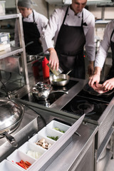Routine job of preparing ingredients for delicious restaurant meals. Cooks at work on the kitchen