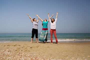 Portrait of three beautiful 40 years old women walking on seaside