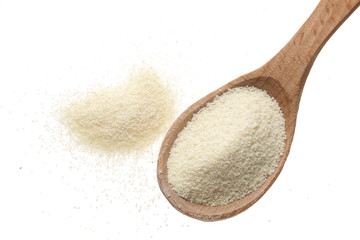 raw semolina in wooden spoon isolated on white background. Top view