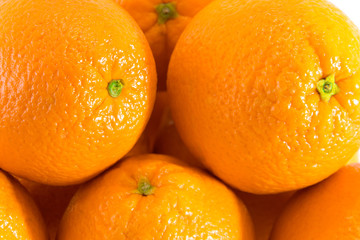 Many fresh raw oranges with navels, orange background