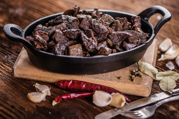 braised beef and lamb meat, liver, lungs and heart dish in black iron cast heavy dish