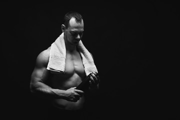 Obraz na płótnie Canvas Male bodybuilder drinking water after workout