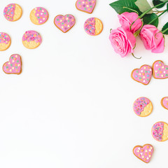 Gingerbread cookies and roses on white background. Frame, copy space. Flat lay. top view.