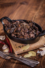 braised beef and lamb meat, liver, lungs and heart dish in black iron cast heavy dish