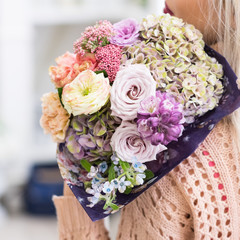 Girl holding a magnificent bouquet of various flowers. Beautiful floral composition. Romantic date concept