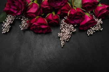  Gothic wedding flowers decor. Dark red or burgundy roses with silver adornment on black background. Bold, daring ,alternative ,and luxury reception party flower arrangement © Photodrive