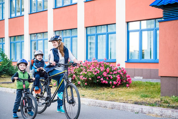 Obraz premium Family cycling, mother with happy kid riding bike outdoors