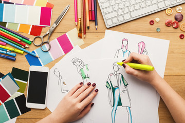 Top view on woman designer drawing clothes sketches