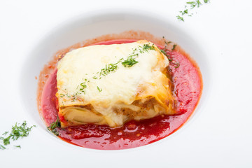 Piece of tasty hot lasagna with red wine. Selective focus