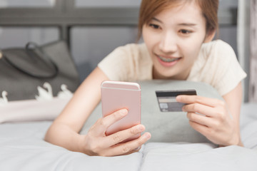 Selective focus Young Asian  woman shopping online pay with credit card in the room.