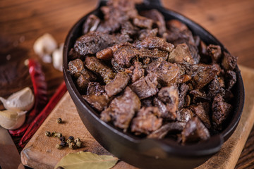braised beef and lamb meat, liver, lungs and heart dish in black iron cast heavy dish