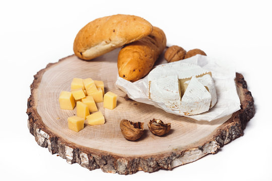 Cheese Camembert, bread, nuts and fruit on old wooden board. Food for wine and romantic, cheese and bread delicatessen isolated on white background...