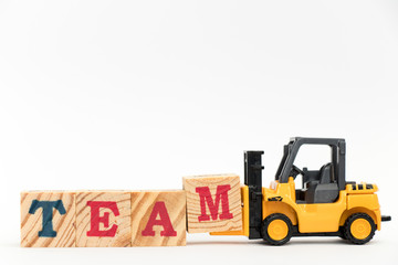 Toy forklift hold letter block M to complete word on team white background