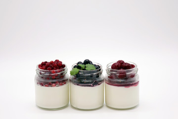 Fresh berries in the jar with the yogurt. On white background.