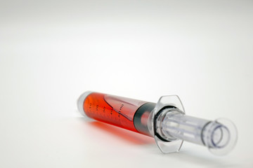 Syringe with blood isolated on white