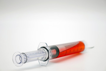 Syringe with blood isolated on white