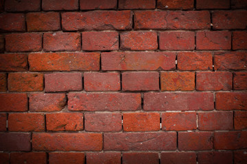 Red brick wall texture background with vignetted corners.